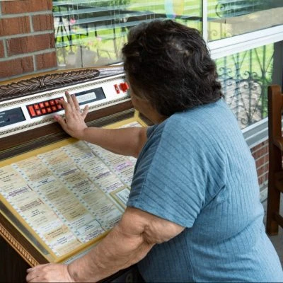 A woman selects a tune on a jukebox