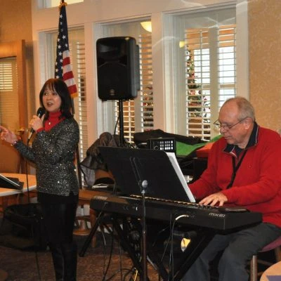 A female musician sings and a male musician plays piano